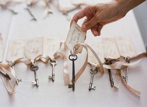 Matching keys laid out in rows on a white table complete with tea stained 