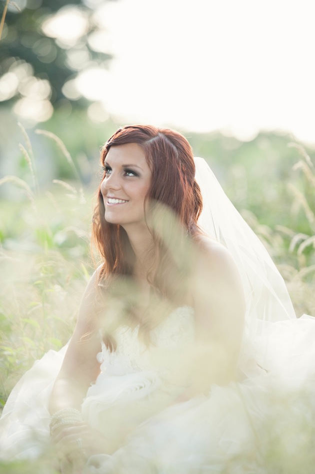 bride sitting in field